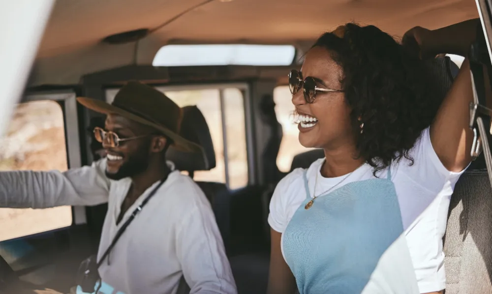 Road trip, driving and black couple drive to travel on a summer vacation with a smile